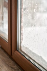 Close up of triple glazed pvc windows during winter. Concept of cozy and warm home during frost weather. Brown window profile.