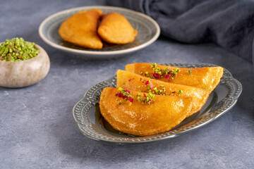 Arabian pancake Qatayef with cheese and pistachio . Traditional ramadan sweets .