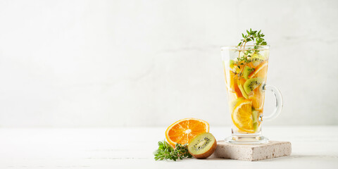 Detox infused water in glass. Refreshing summer homemade cocktail with fruit, berries and citrus