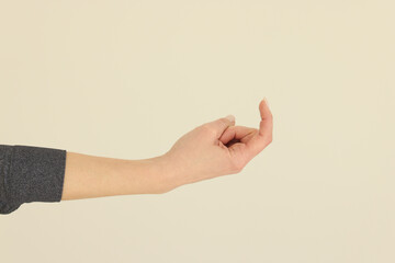 Naklejka premium Hand of woman making beckoning sign on beige background