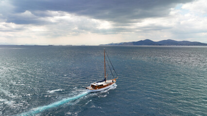 Fototapeta premium Aerial drone photo of wooden sail boat cruising deep blue Mediterranean sea