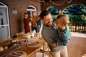 Playful father and son have fun on patio.