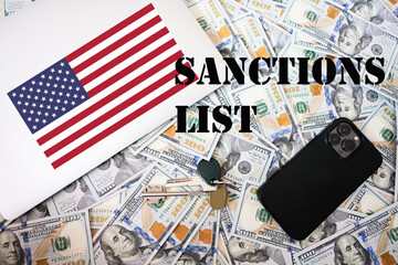 Sanctions list concept. USA flag, dollar money with keys, laptop and phone background.