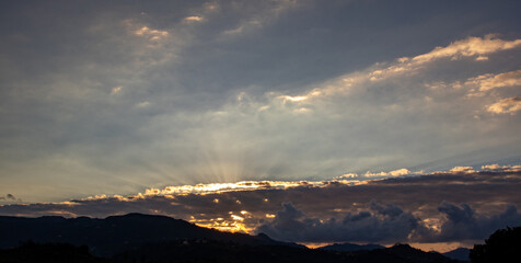 sun rising through the clouds, horizontal scenery 
