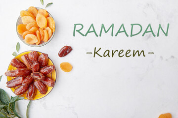 Fototapeta premium Ramadan Kareem text background. Healthy desserts. Fast diet food - dried apricots, dates