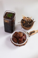 glass of ice black tea on a white background served with dates fruit. ramadan. muslim. halal