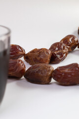 Cup of black tea served with dates fruit. ramadan. muslim. halal. takjil. isolated on white background