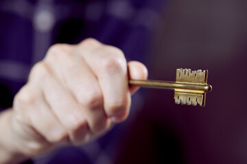  Close up of human hand holding golden key