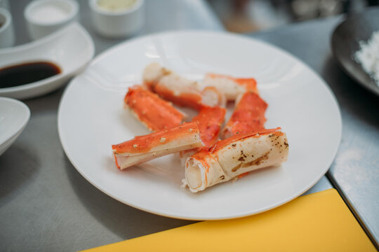 Fresh red Kamchatka crab legs on the table and ingredients in the restaurant kitchen.