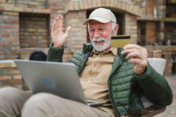 Man senior caucasian male shopping online sit with laptop computer