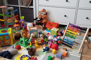 a realistic shot of life as it is, a mess of children's toys in an apartment at home, mountains of plastic and wooden toys for a baby