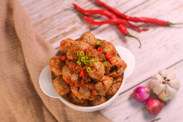 Selective focus of Bakso Mercon (spicy meatballs) on wooden spoon. traditional food from Java, Indonesia, cooked with various herbs.