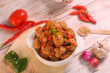 Selective focus of Bakso Mercon (spicy meatballs) on wooden spoon. traditional food from Java, Indonesia, cooked with various herbs.