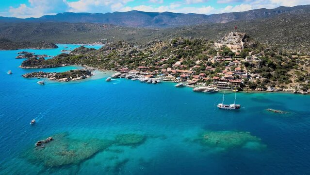Drone footage exploring Simena Castle (Kalek&ouml;y), beach, and yachts, showcasing the rich history and picturesque Mediterranean setting in Antalya, Turkey.