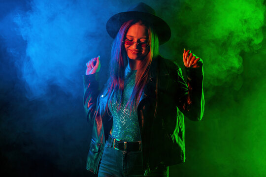 Fashionable woman in neon multi-color light. Smoky background, night party © kohanova1991