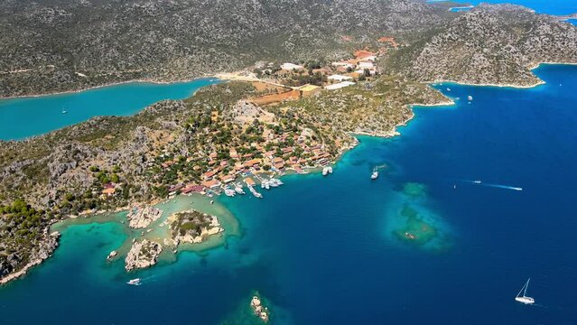 Aerial view of Simena Castle (Kalek&ouml;y), beach, and yachts, showcasing the captivating blend of history, nature, and Mediterranean culture in Antalya, Turkey.