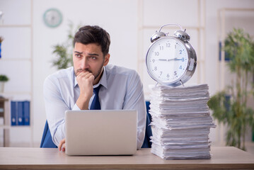 Young male employee in time management concept