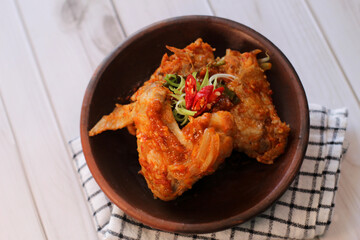 sayap mercon or spicy chicken wings serving on tray bamboo. tasty grilled chicken wings on a white dish, top view. sayap pedas.