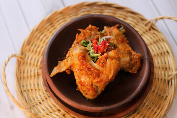 sayap mercon or spicy chicken wings serving on tray bamboo. tasty grilled chicken wings on a white dish, top view. sayap pedas.