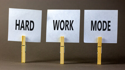 Hard work mode symbol. Concept words Hard work mode on white paper on wooden clothespin on a beautiful grey table grey background. Business and Hard work mode concept. Copy space.