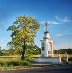 A roadside shrine in Krasnystaw by a blooming acacia tree