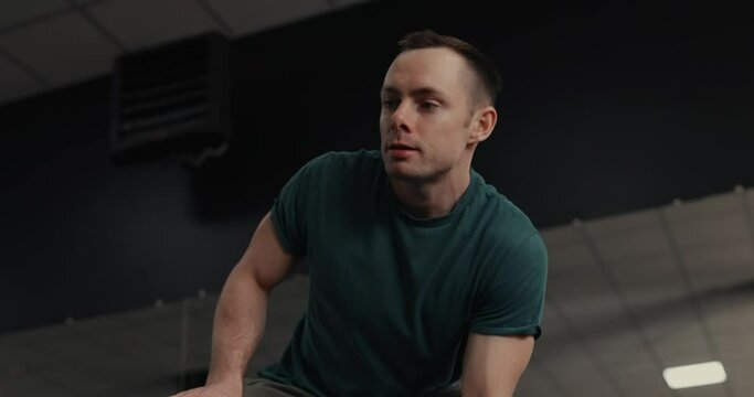 Strong man lifting dumbbell at the gym pumping bicep muscles