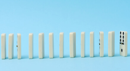 Dominoes standing in a row on a blue background, gambling