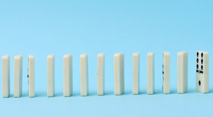 Dominoes standing in a row on a blue background, gambling