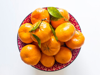 Piccoli agrumi con buccia rosso-arancione intenso all'interno di una ciotola rosso-bianca. Ripresa...