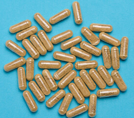 Transparent medical capsules on a blue background, tablets for treatment, vitamins