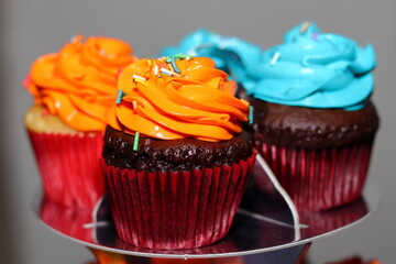 Cupcakes with orange and blue cream on top