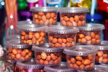 Small jars filled with tangy peanuts and stacked in a pyramid shape