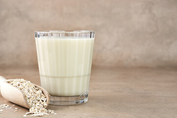 A glass of oat milk and oatmeal on a beige background. copy space. The concept of alternative lactose-free dairy products.