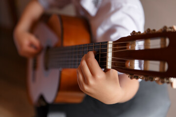 Fototapeta premium Young handsome guitar player, boy with guitar, children playing the guitar