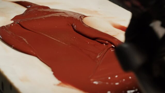 Woman chef confectioner making chocolate candy, pouring cacao for mousse pink cake, creamy dessert close-up gastro art. Restaurant dessert, sugar sweets, almond chocolate mousse.