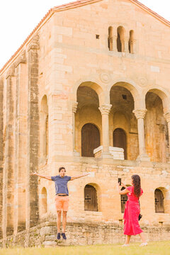 woman take a photo with smartphone to a man in Santa Maria del Naranco oviedo, Asturias Church.