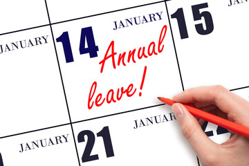 Hand writing the text ANNUAL LEAVE and drawing the sun on the calendar date January 14