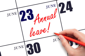 Hand writing the text ANNUAL LEAVE and drawing the sun on the calendar date June 23