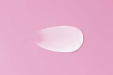Close-up smear of cream texture on a pink background