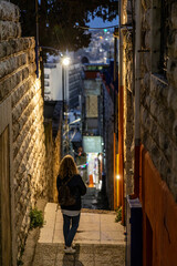 Amman, Jordan A woman tourist explores the narrow back alleys of the capital at night.
