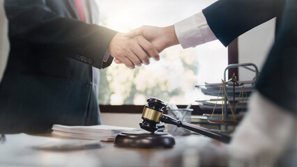 Lawyer consultant shaking hand with client sign contract agreement document in law firm. Business meeting Handshake..