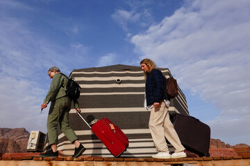 Wadi Rum, Jordan   Mother and daughter tourists with suitcases at a campist in the desert.