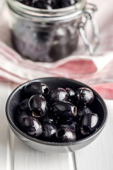 Pitted black olives in bowl on kitchen table.