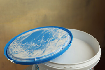 A bucket of white paint. Painting works in the premises. Tidying up the apartment. Repair of premises.