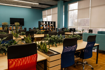 Fashion and modern office interiors. Interior of modern office. Comfortable co-working space. Spacious modern coworking office with eco style furniture, wooden floor and comfortable workplaces.