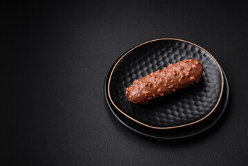Delicious fresh eclair cake or profiterole with chocolate and nuts