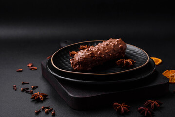 Delicious fresh eclair cake or profiterole with chocolate and nuts
