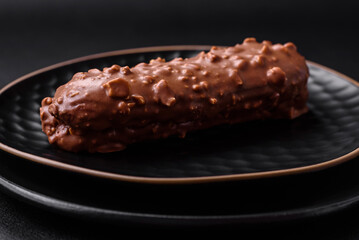 Delicious fresh eclair cake or profiterole with chocolate and nuts