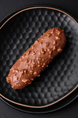 Delicious fresh eclair cake or profiterole with chocolate and nuts