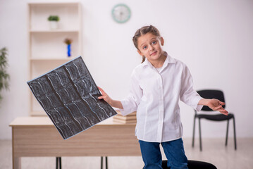 Small girl playing doctor radiologist in the clinic